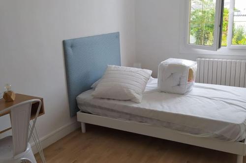 łóżko z białą pościelą i poduszkami w pokoju w obiekcie Maison 6 chambres avec jardin à Angers w mieście Angers
