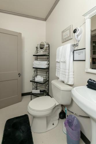 a bathroom with a white toilet and a sink at Memphis Belvedere Suites Studio in Memphis