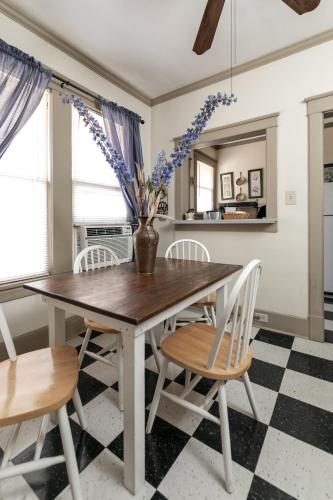 a dining room table with chairs and a vase with flowers at Memphis Belvedere Suites Studio in Memphis