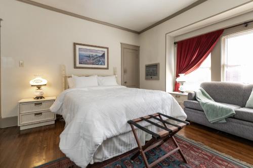a bedroom with a large bed and a couch at Memphis Belvedere Suites Studio in Memphis