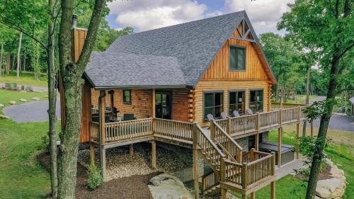 a cabin in the woods with a large deck at Space Mountain in McHenry