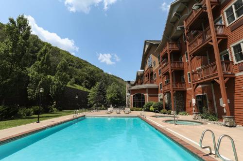 a swimming pool in front of a building at Kaatskill Mountain Club & Condos by Vail Resorts in Hunter