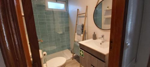 uma casa de banho com um lavatório, um WC e um espelho. em Ofelia Terrace House em Portimão