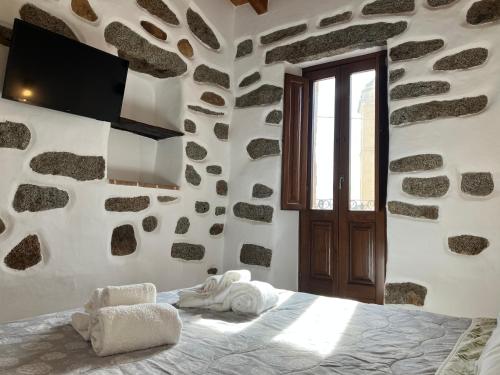 a bedroom with a bed in a stone wall at La Corte Dei Baroni in Loceri