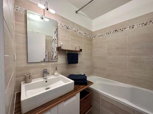 a bathroom with a white sink and a bath tub at Appartement climatisé entre plage et port de Saint Mandrier in Saint-Mandrier-sur-Mer