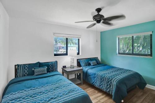 1 dormitorio con 2 camas y ventilador de techo en Tiki@theLauderdale, en Pompano Beach