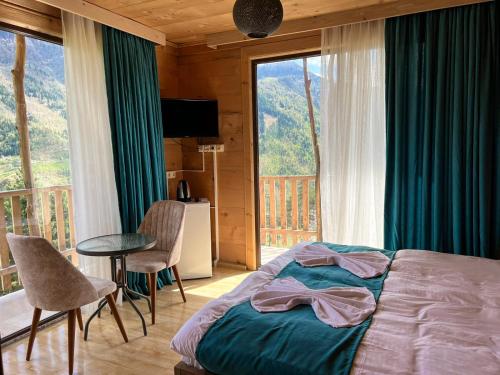 a bedroom with a bed and a balcony with a view at Hotel Khulo lnn in Khulo
