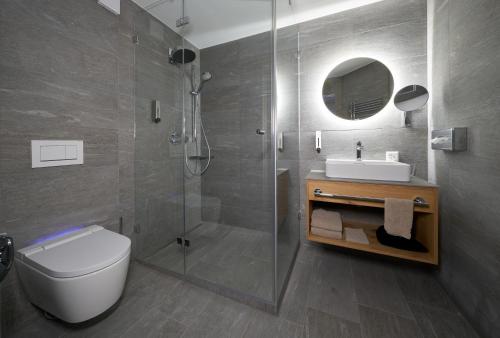 a bathroom with a shower and a toilet and a sink at Aparthotel Grischuna in Samnaun