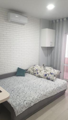 1 cama en un dormitorio con una pared blanca en Аренда уютной квартиры на сутки с видом на Море и Есть бомбоубежище en Kryzhanivka