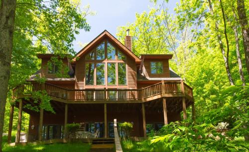 a log cabin in the woods with trees at Lakey McLakeHouse in Swanton