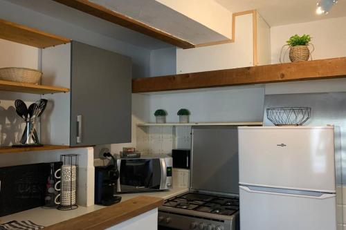 une cuisine avec un réfrigérateur et un micro-ondes dans l'établissement Duplex à Monteux centre, 5 couchages distincts, LOCAL VELOS, à Monteux