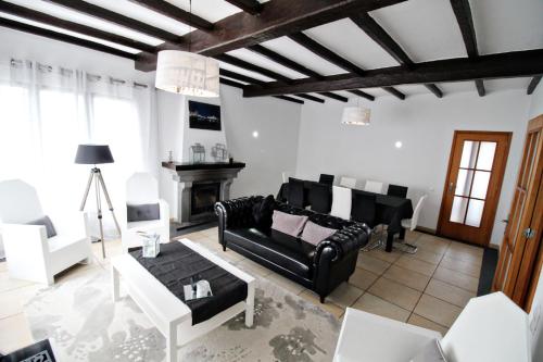 a living room with black leather furniture and a fireplace at Vivenda Atlântida in Ponta Delgada