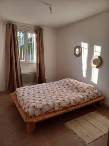 a bedroom with a bed in a room with a window at Appartement 60m2 lumineux in Avignon