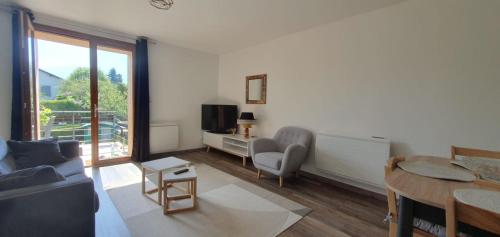 un salon avec un canapé, une table et une télévision dans l'établissement Duplex proche de Genève et du lac léman, à Veigy-Foncenex