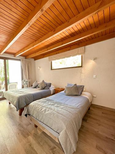 a bedroom with two beds and a window at Aldea del Valle - Elqui Villas, Pisco Elqui in Pisco Elqui