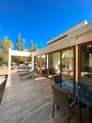 a patio with a glass table and chairs on it at Aldea del Valle - Elqui Villas, Pisco Elqui in Pisco Elqui