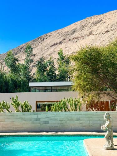 a house with a swimming pool in front of a mountain at Aldea del Valle - Elqui Villas, Pisco Elqui in Pisco Elqui