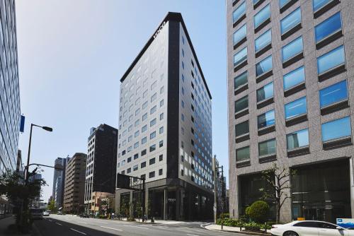 a tall building in the middle of a city at voco Osaka Central by IHG in Osaka