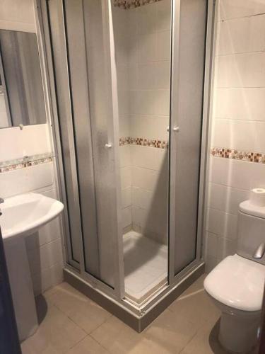 a bathroom with a shower and a toilet and a sink at Appartement Neuf en Face de la Plage - FNIDEQ in Fnidek