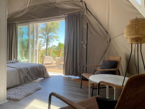 a bedroom with a tent with a table and chairs at Nature Nest Aljezur in Aljezur