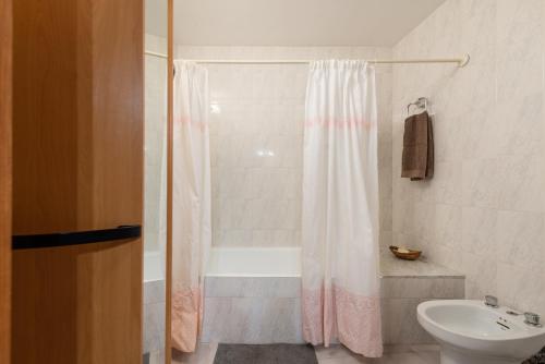 y baño con cortina de ducha y lavamanos. en Townhouse Can Bregat, en Pollensa