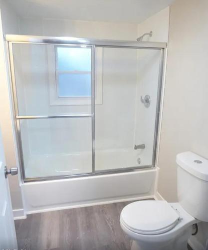 a white bathroom with a shower and a toilet at Spacious home in Missouri City