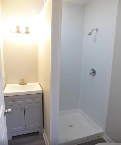 a white bathroom with a sink and a shower at Spacious home in Missouri City