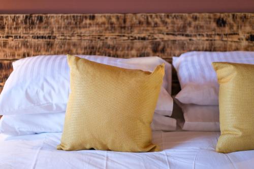 a bed with white sheets and two yellow pillows at Craig Walk Suite in Bowness-on-Windermere
