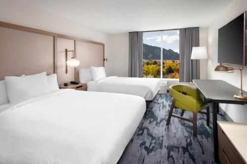 a hotel room with two beds and a desk and a window at Fairfield Inn & Suites Boulder in Boulder