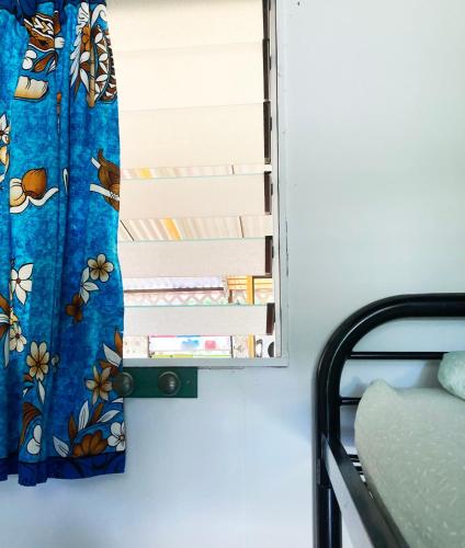 a mirror hanging on a wall next to a bed at Pension TE MITI - PLAGE-BEACH 200m - Mahana Parc & Vaiava Beach pk18 - B&B CHAMBRES ou DORTOIR in Punaauia