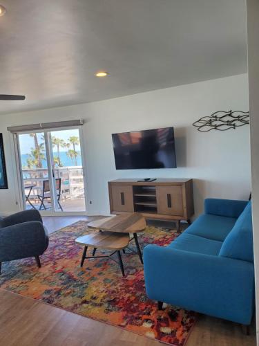 a living room with a blue couch and a tv at Sea Horse Resort in San Clemente
