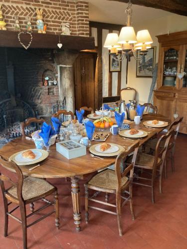 une grande table en bois avec des chaises et de la nourriture dessus dans l'établissement L'Armandière, à Sainte-Colombe