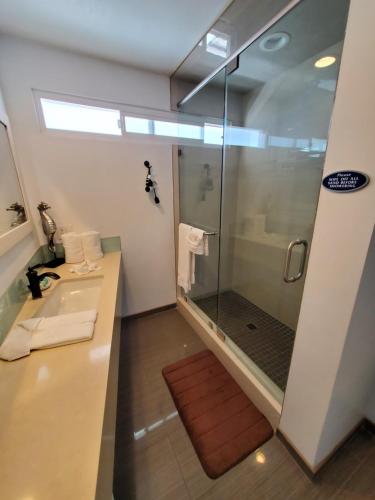 a bathroom with a glass shower and a sink at Sea Horse Resort in San Clemente