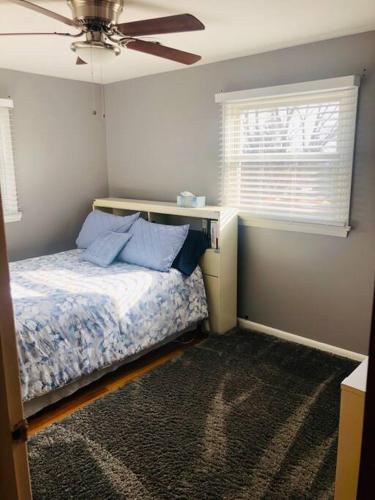 a bedroom with a bed with a ceiling fan and a window at Family-Friendly Home CLOSE to SYR Univ DWNTWN & THE DOME! Location Location Location in Syracuse
