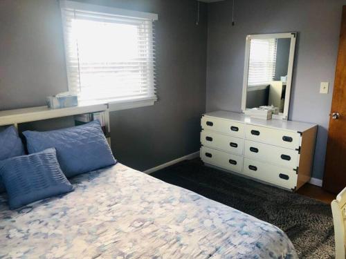 a bedroom with a bed and a dresser and a mirror at Family-Friendly Home CLOSE to SYR Univ DWNTWN & THE DOME! Location Location Location in Syracuse