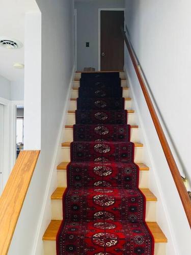 a stairway with a red and black rug on it at Family-Friendly Home CLOSE to SYR Univ DWNTWN & THE DOME! Location Location Location in Syracuse