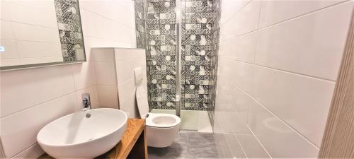 a white bathroom with a sink and a toilet at Villa Kajgo-Pag in Pag