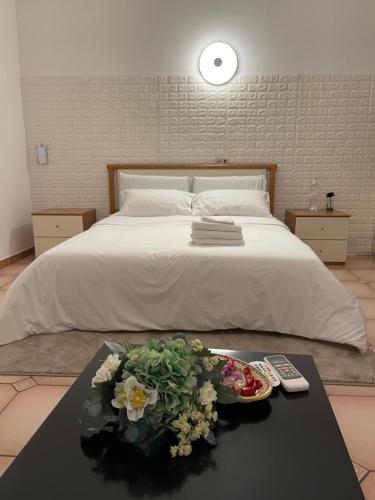 ein Schlafzimmer mit einem Bett und einem Tisch mit Blumen darauf in der Unterkunft Just Relax in Le Casette