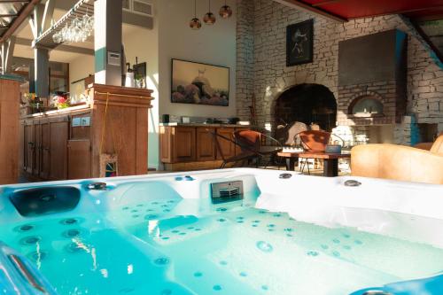 Dommartin的住宿－Villa des gones，带壁炉的客厅设有浴缸。