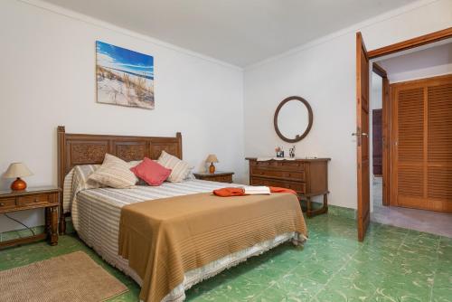a bedroom with a bed and a mirror on the wall at Townhouse Can Bregat in Pollença