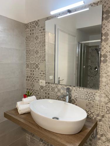 a bathroom with a white sink and a mirror at PALM House Affitta camere in Tortolì