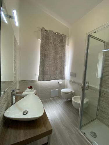 a bathroom with a toilet and a sink and a shower at PALM House Affitta camere in Tortolì