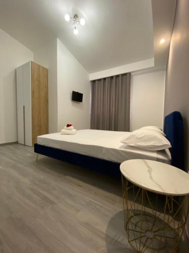 a bedroom with a large bed and a table at PALM House Affitta camere in Tortolì