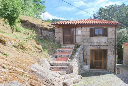 a small house with stairs leading to a door at Retiro de Várzeas . Casa de Turismo Rural in Vieira do Minho
