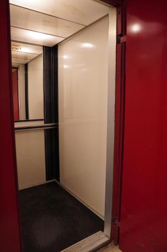 a glass door of a closet with a red wall at Poseidon's Premium Apartment in Katerini