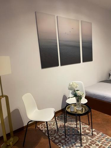 Avdkapartment في ميلانو: غرفة بها كرسيين وطاولة وسرير