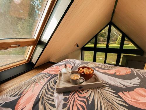 ein Tablett mit Essen auf einem Bett in einem Zimmer mit Fenstern in der Unterkunft Private Stay Zen House to unplug and recharge in Tuimõisa