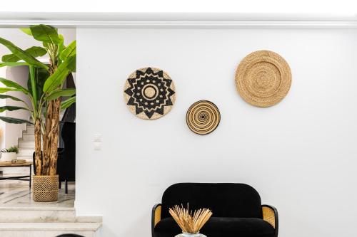 a living room with a black chair and hats on the wall at Anatoli Hotel in Naxos Chora
