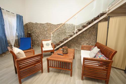 a living room with chairs and a table and stairs at Dimore di mare - Beachfront Apartments in Santa Flavia