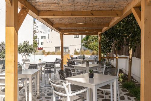an outdoor patio with white tables and chairs at Anatoli Hotel in Naxos Chora
